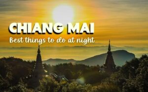 What to do in Chiang Mai at night: A dramatic photograph of a sunrise or sunset over a misty mountainous landscape near Chiang Mai, possibly Doi Inthanon, with the sun glaring brightly at the center. Two dark, conical Buddhist chedis (stupas) are silhouetted in the foreground, surrounded by trees. The text "CHIANG MAI Best things to do at night" is overlaid on the image.