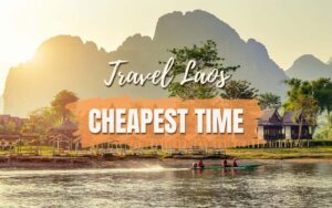 Cheapest time to travel to Laos: A scenic riverside view in Laos with mountains in the background, houses on stilts, and people kayaking on calm water at sunset, with the text “Travel Laos – Cheapest Time.”