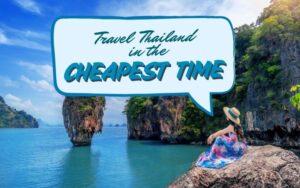Cheapest Time to Travel to Thailand: A woman wearing a colorful dress and hat sits on a rock overlooking the turquoise sea and limestone cliffs of Phang Nga Bay in Thailand, with the text “Travel Thailand in the Cheapest Time” written in a blue speech bubble.
